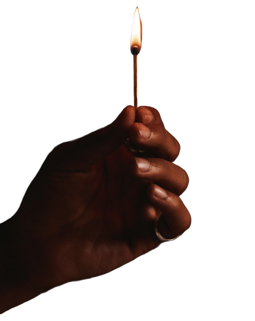 Hand holding a lit match, symbolizing hope, resilience, guidance, and light during difficult times.