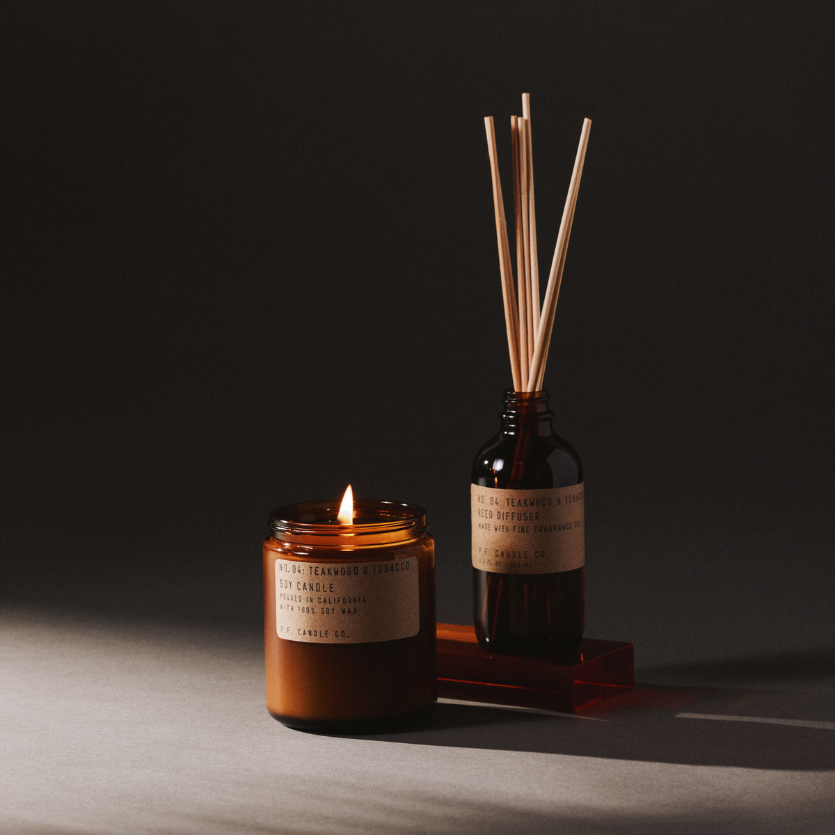 teakwood & tobacco candle and reed diffuser set on a dark background